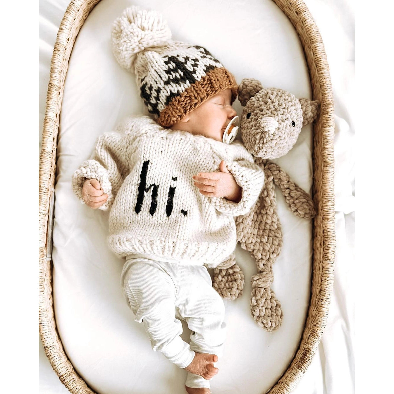 Newborn baby in a knitted outfit with &