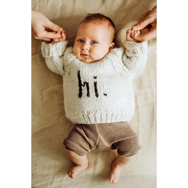 Baby wearing a knitted outfit with &