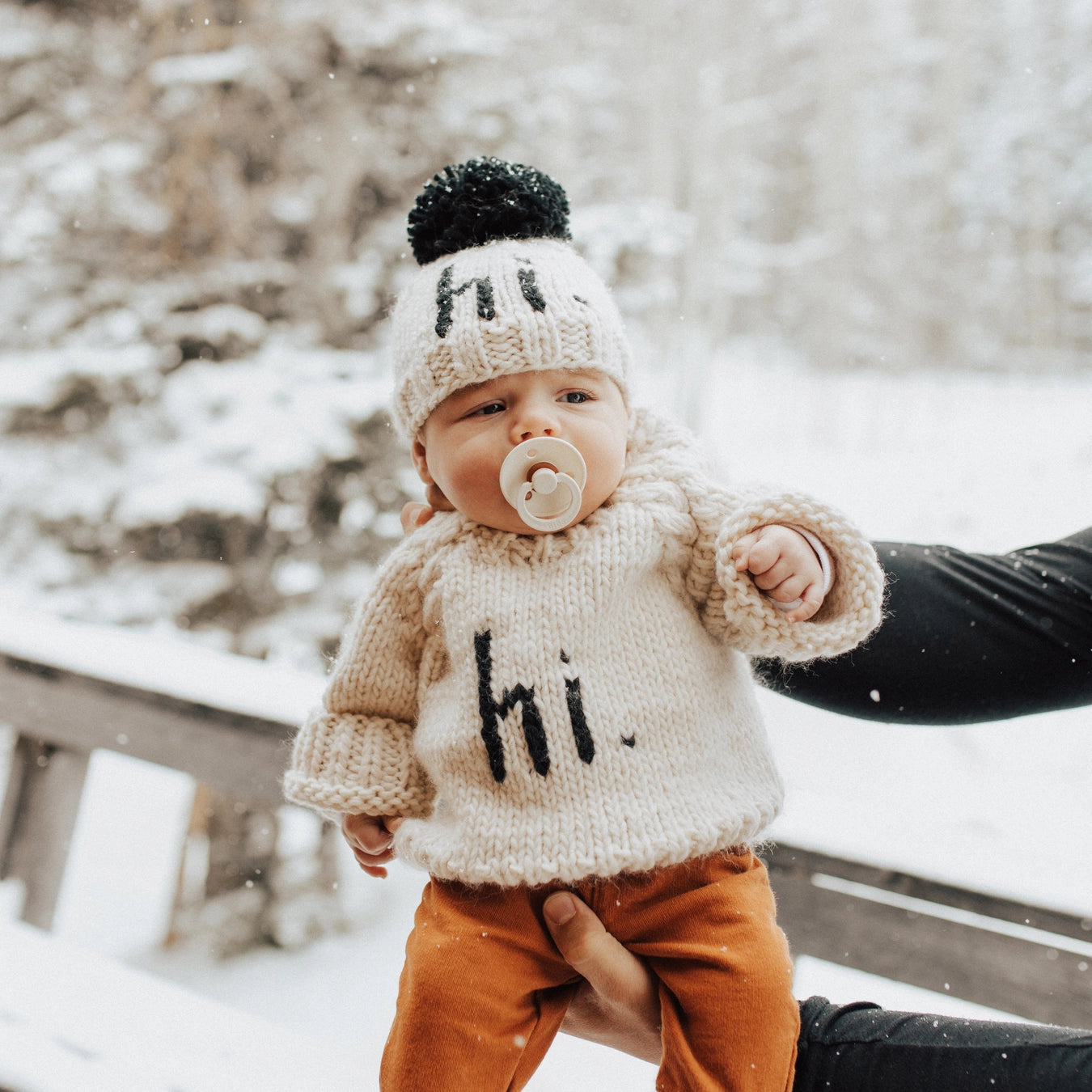 Baby in a knitted sweater and hat with &