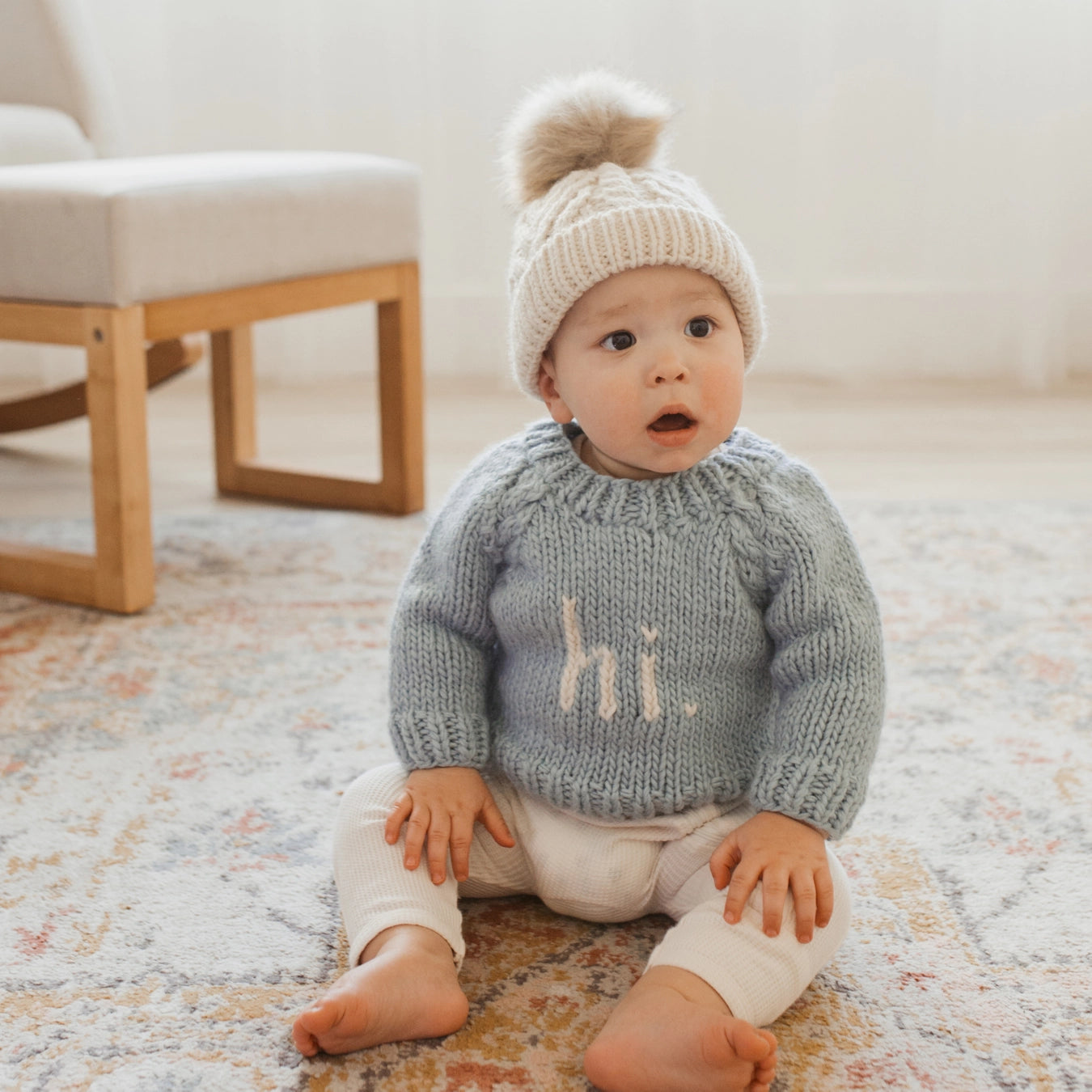 Baby wearing a knitted sweater with &
