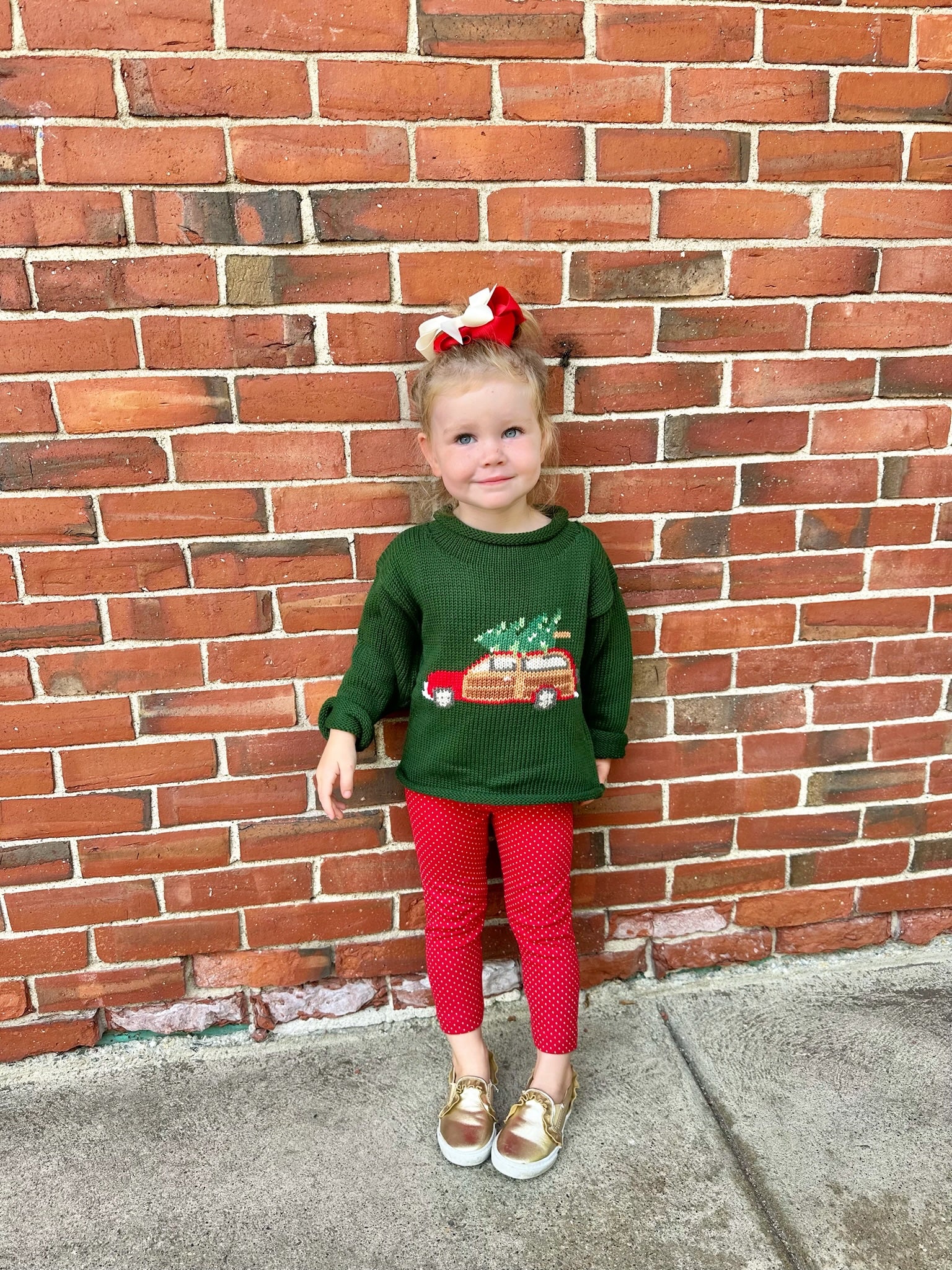 girl wearing green christmas sweater and red leggings