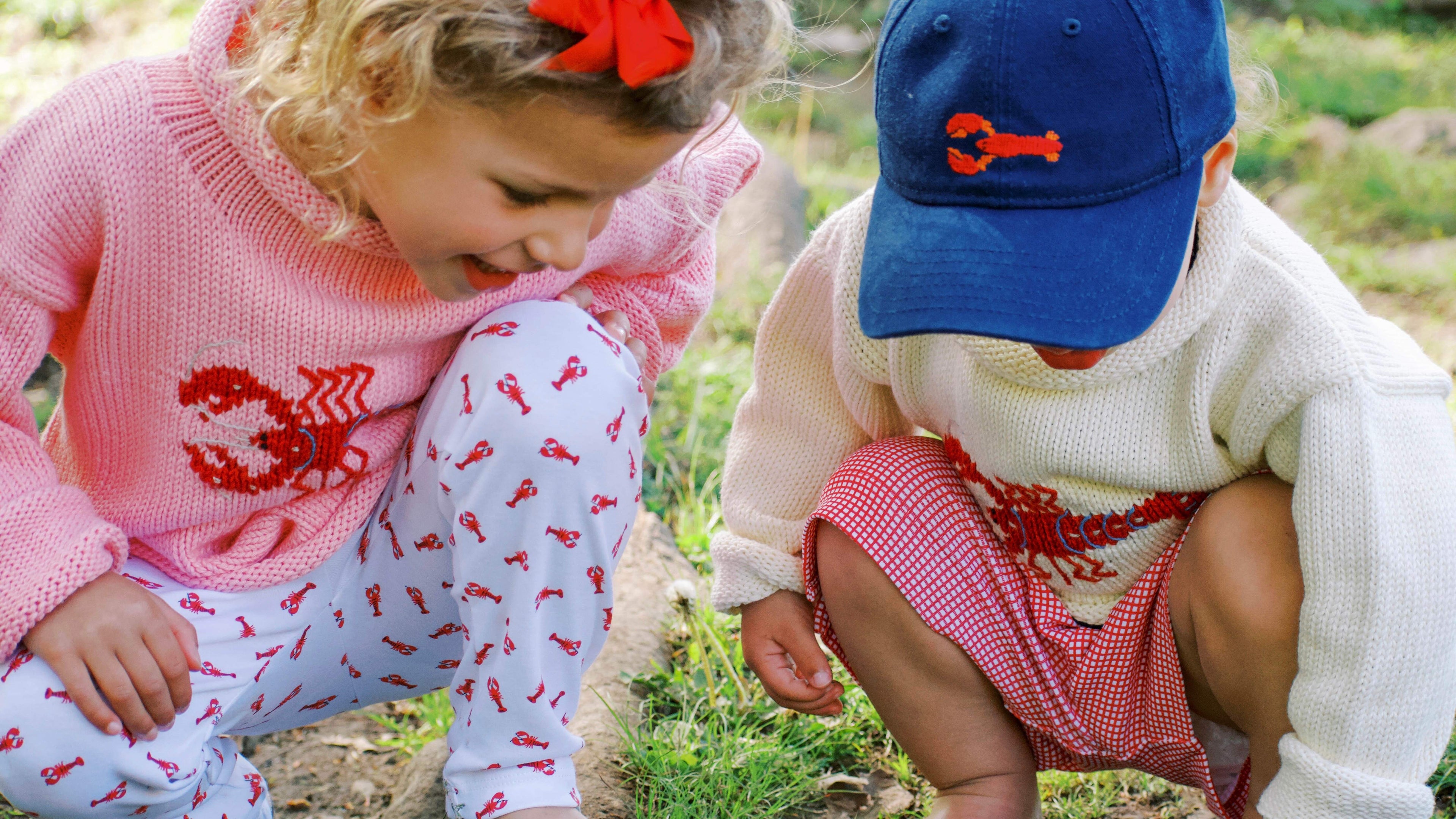 boy and a girl playing in the grass wearing lobster themed outfits