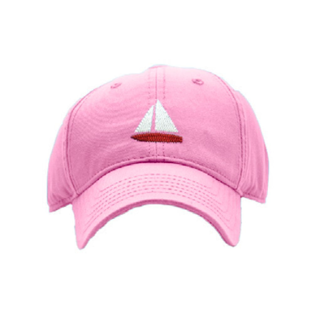 Pink cap with a sailboat emblem on a white background