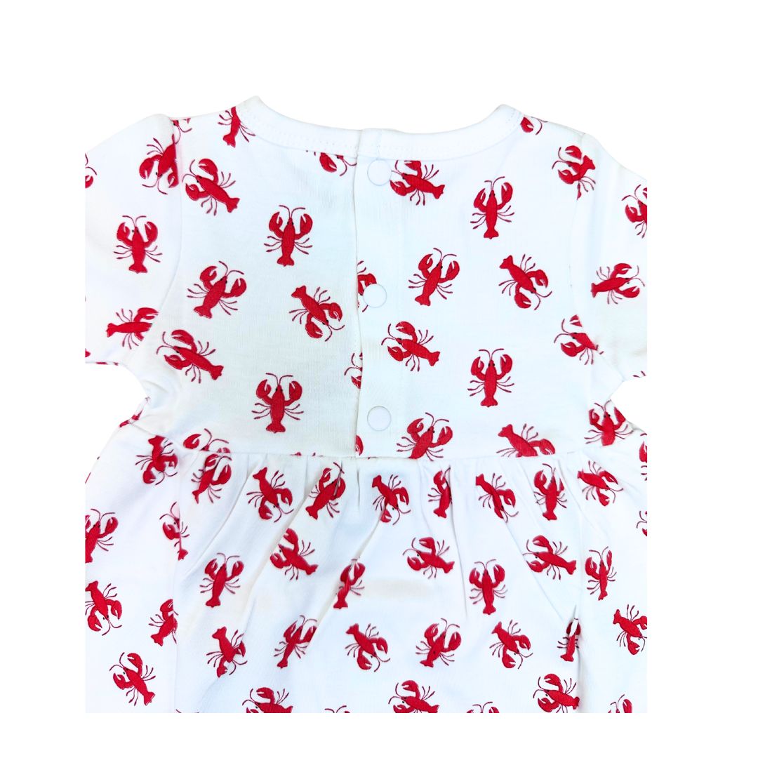 White baby romper with red lobster pattern on a white background