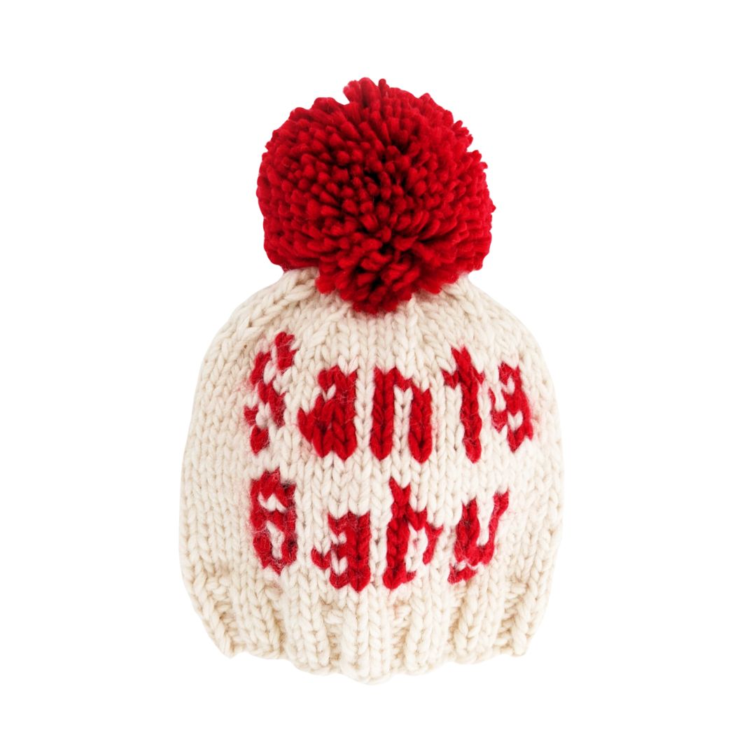 Knitted baby hat with red pom-pom and &