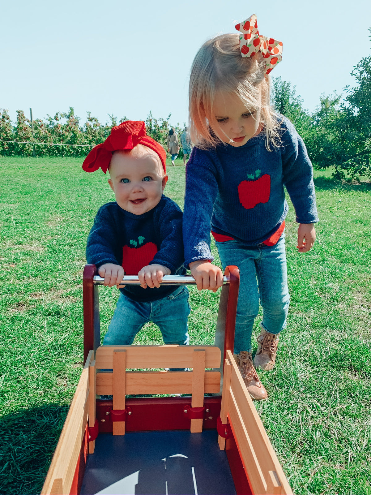 sisters wearing matching apple sweaters