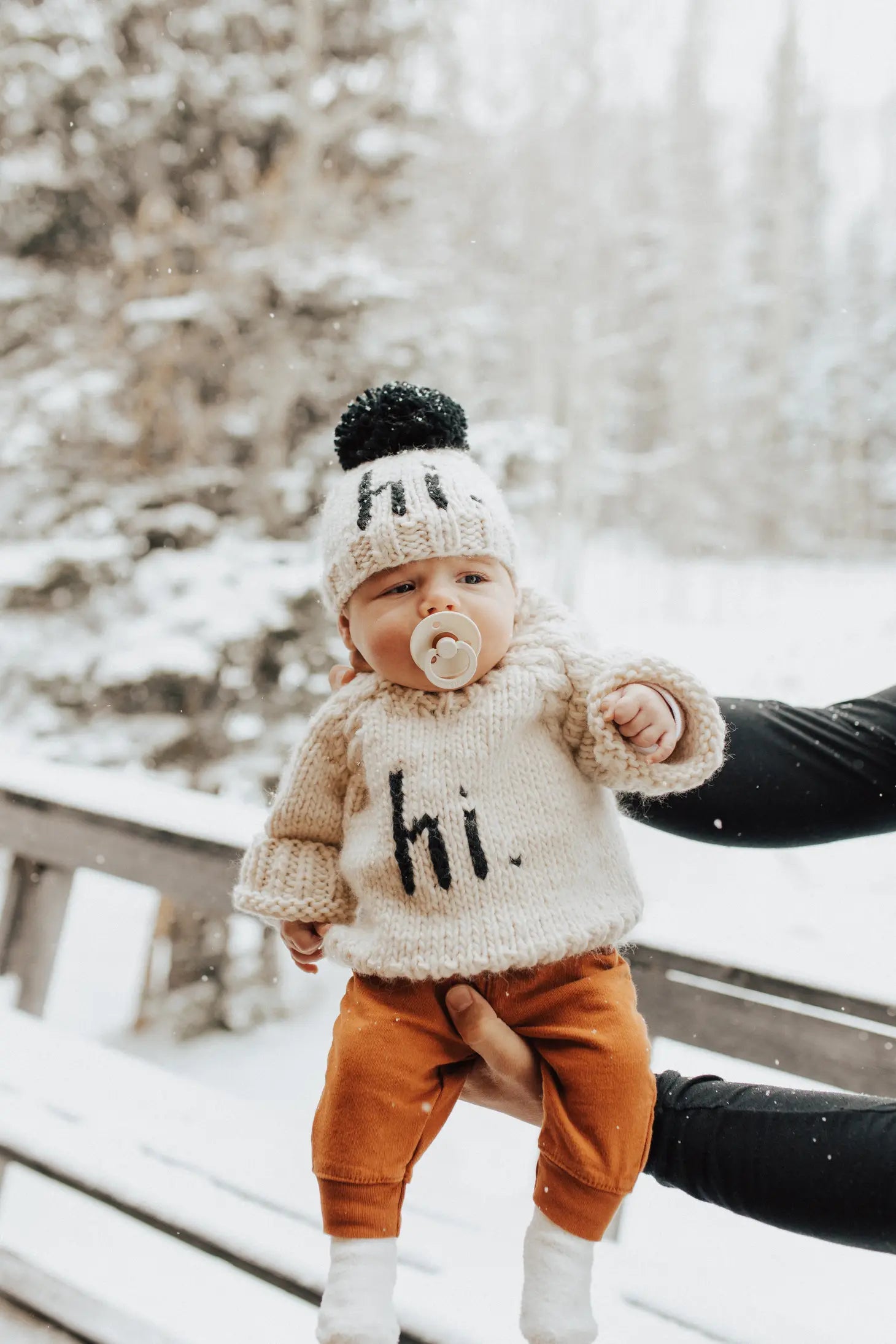 baby in snow wearing hi beanie