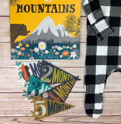 black and white buffalo check footie with Mountains book and pennants laid out, 1-5 months shown