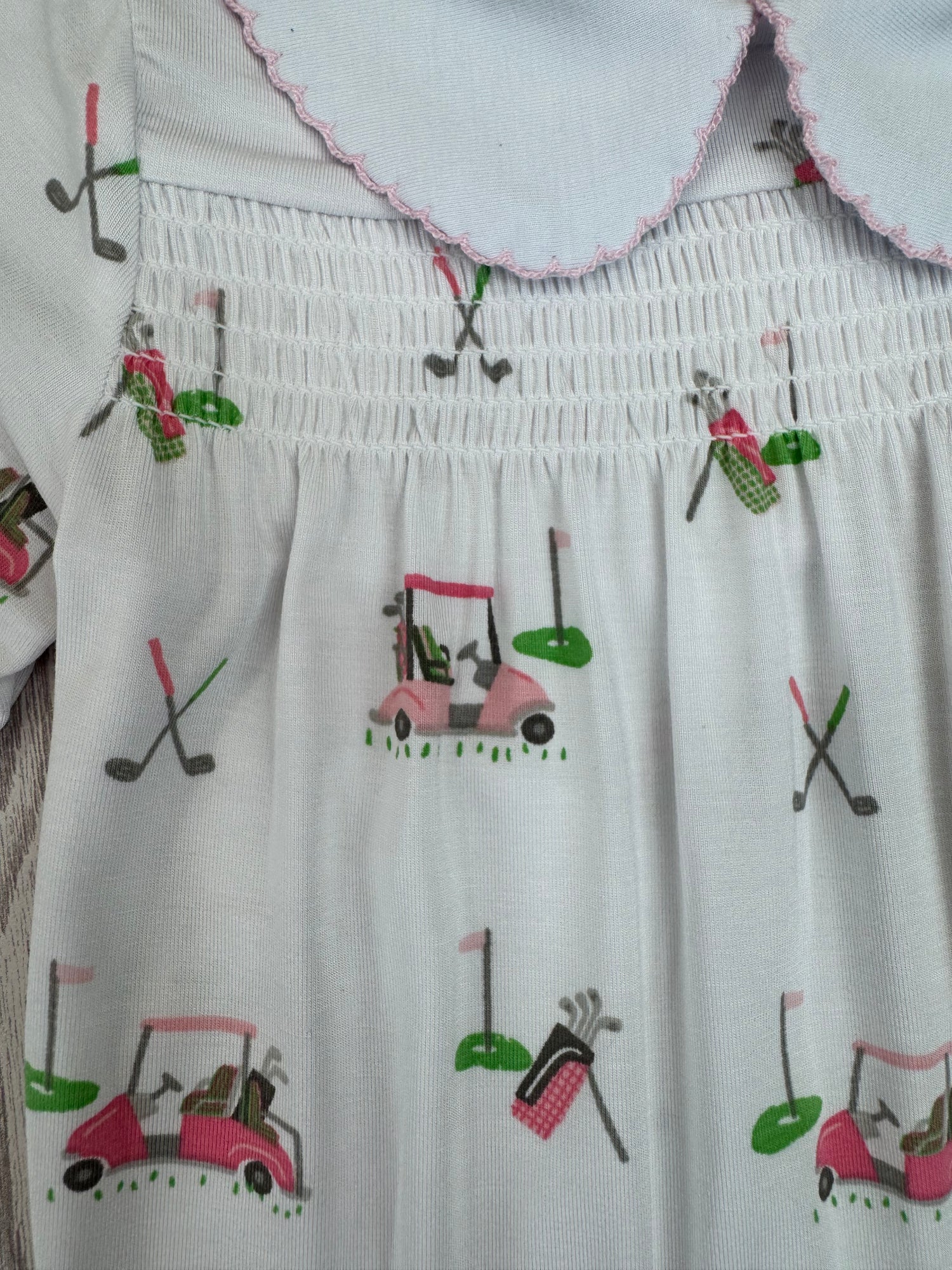 White dress with colorful golf-themed embroidery on a white background