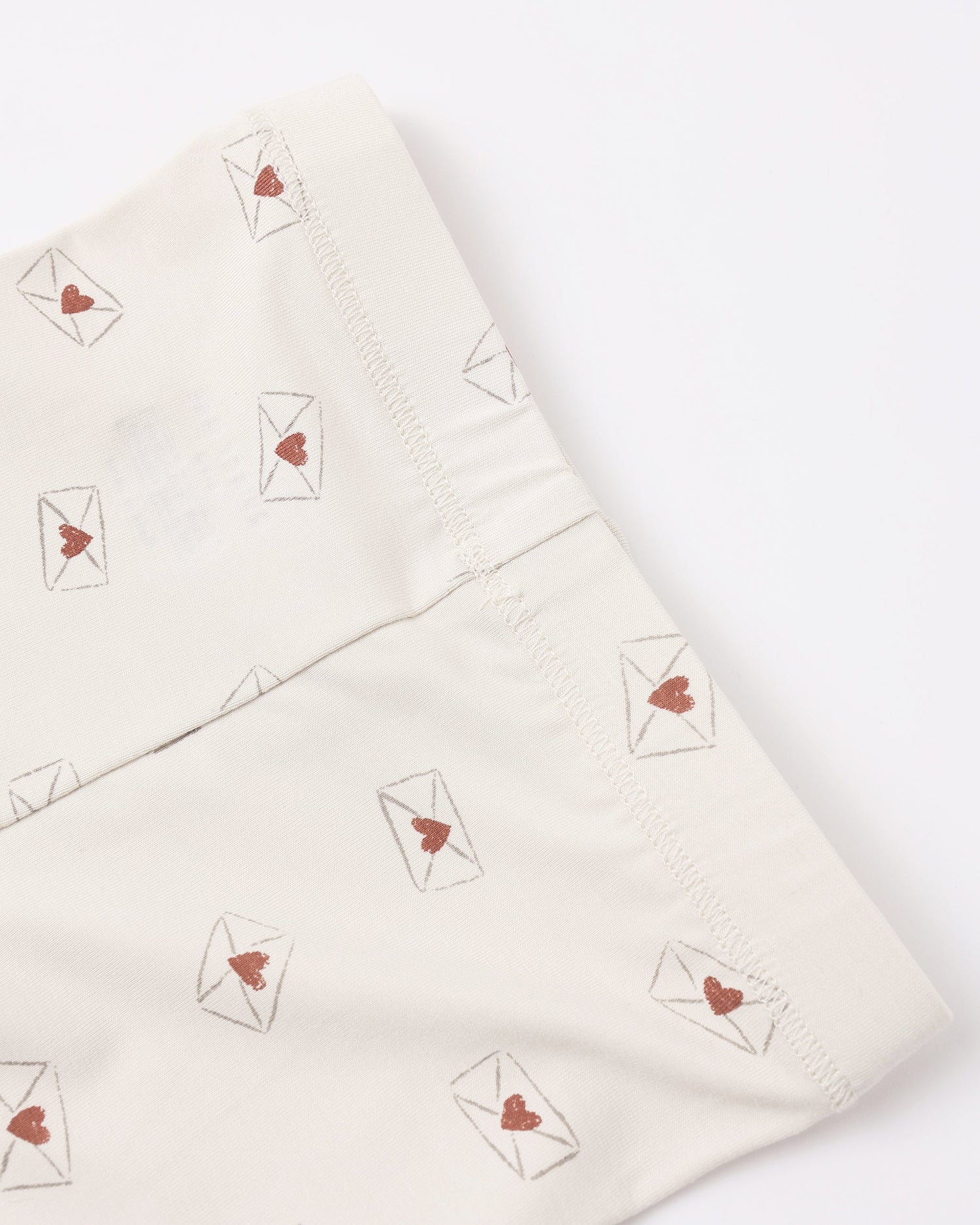 Folded fabric with heart and envelope patterns on a white background