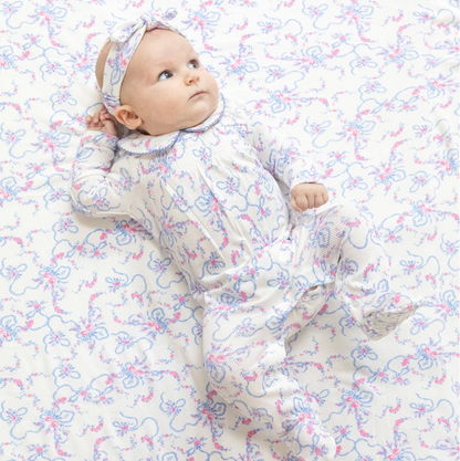 Baby in a floral outfit lying on a matching floral blanket