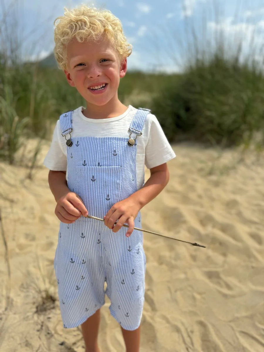 boy wearing the overalls on a beach