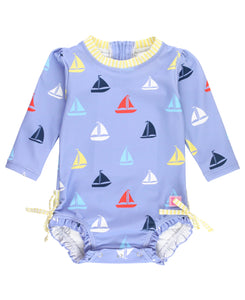 blue long sleeve rashguard suit with multi color sailboats all over and yellow seersucker trim