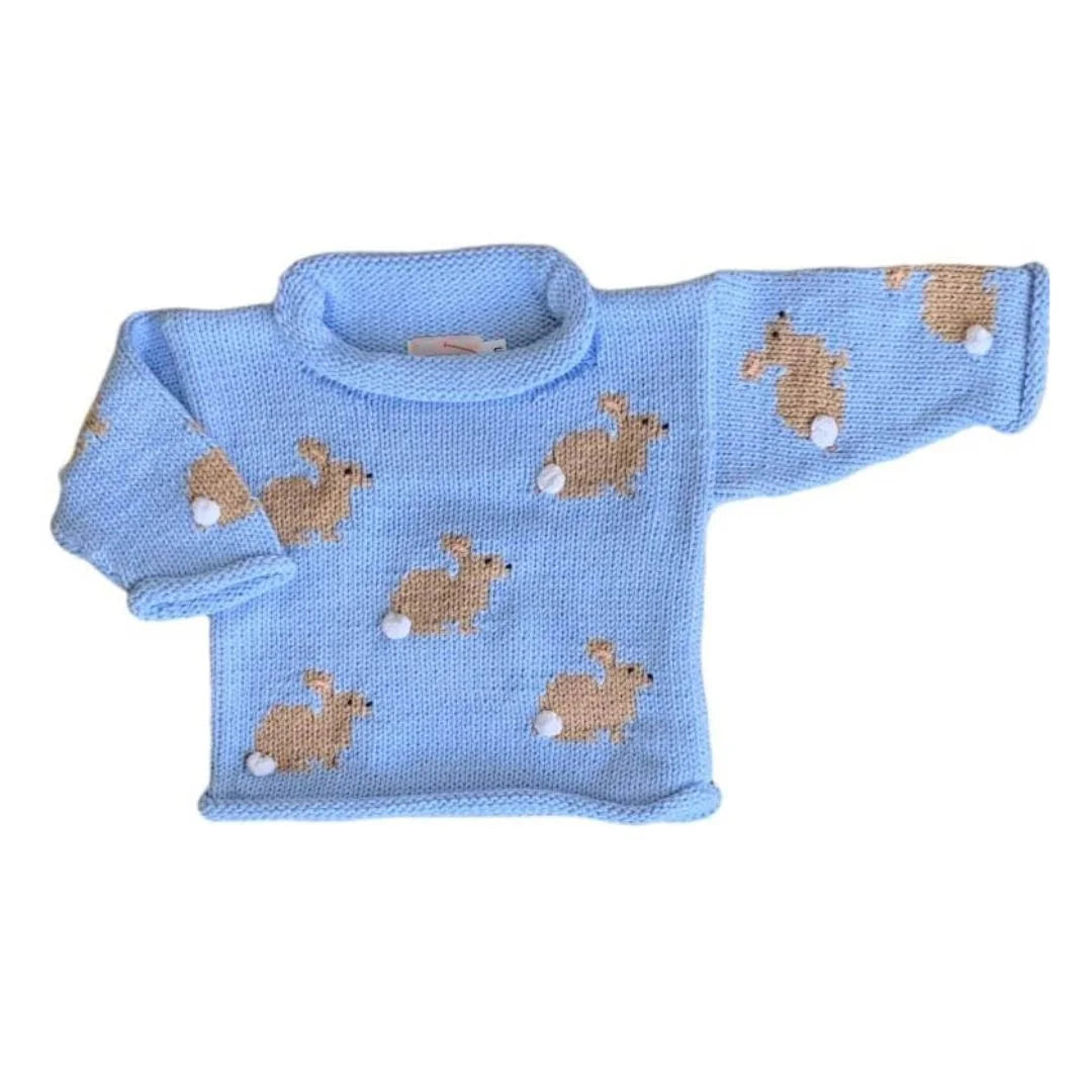 light blue roll neck sweater with small tan bunnies embroidered into the knit with small white pom poms sewn on to the sweater as bunny tails