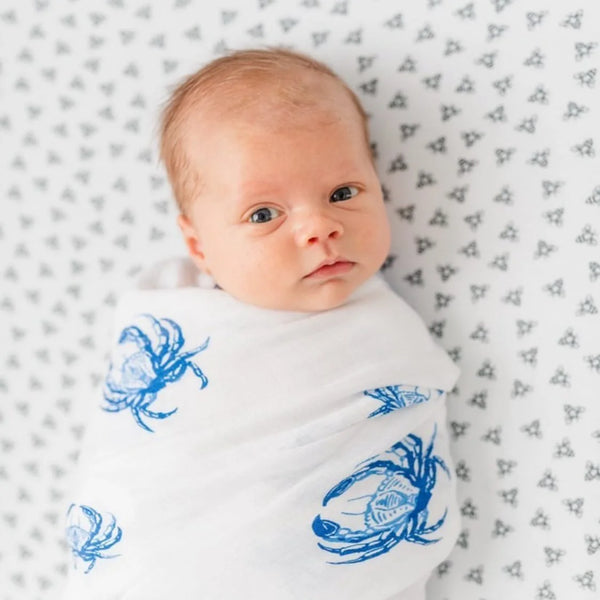 white baby swaddle with blue crab design