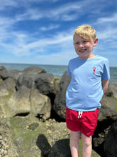 boy wearing shirt with red shorts