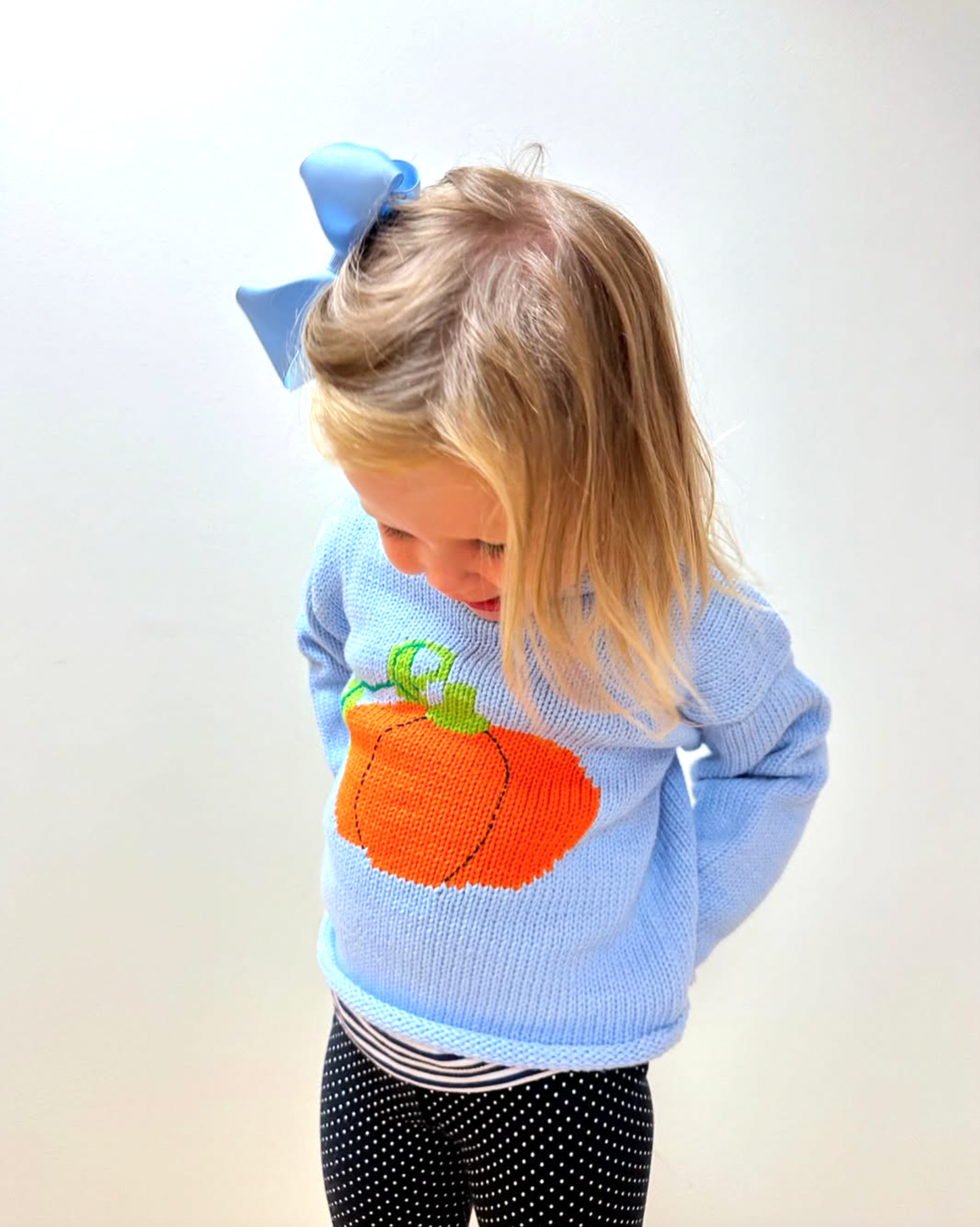 girl wearing blue pumpkin sweater