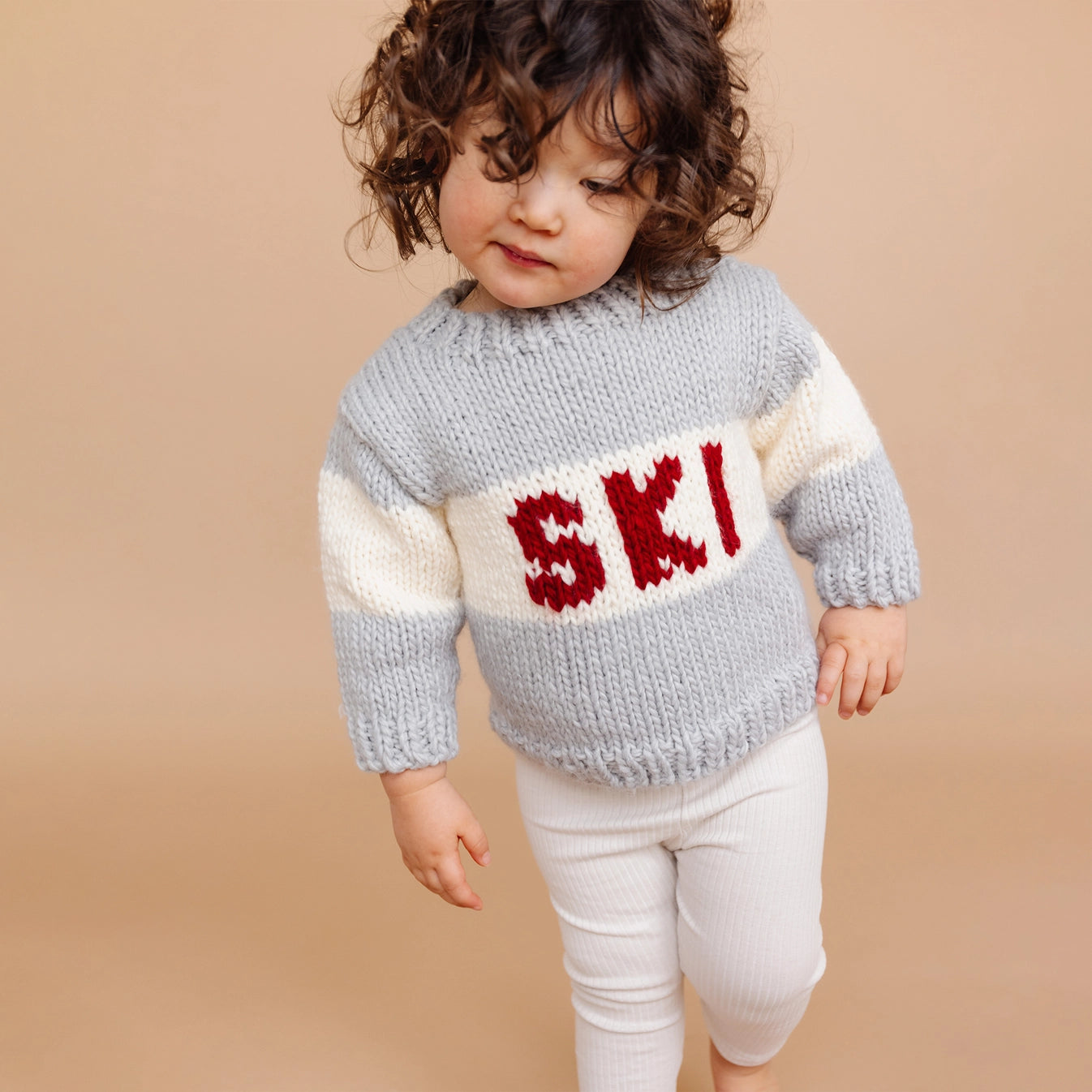 Child wearing a knitted sweater with &
