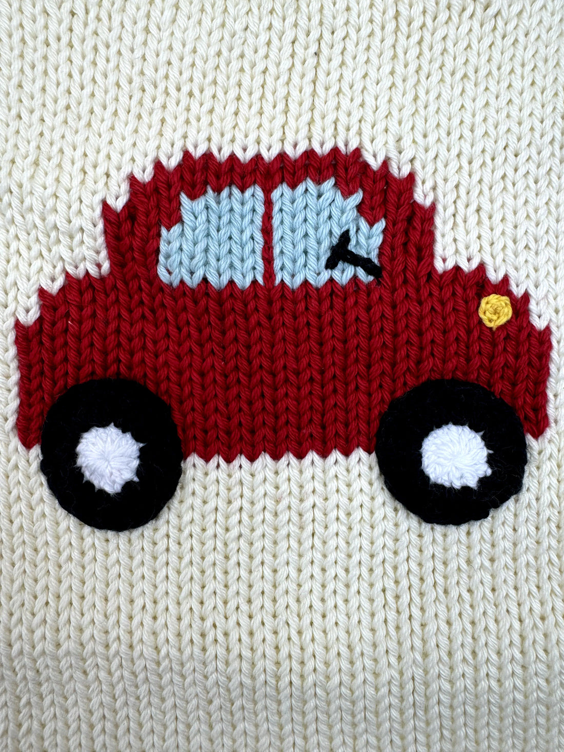 Knitted red truck with black wheels on a white background