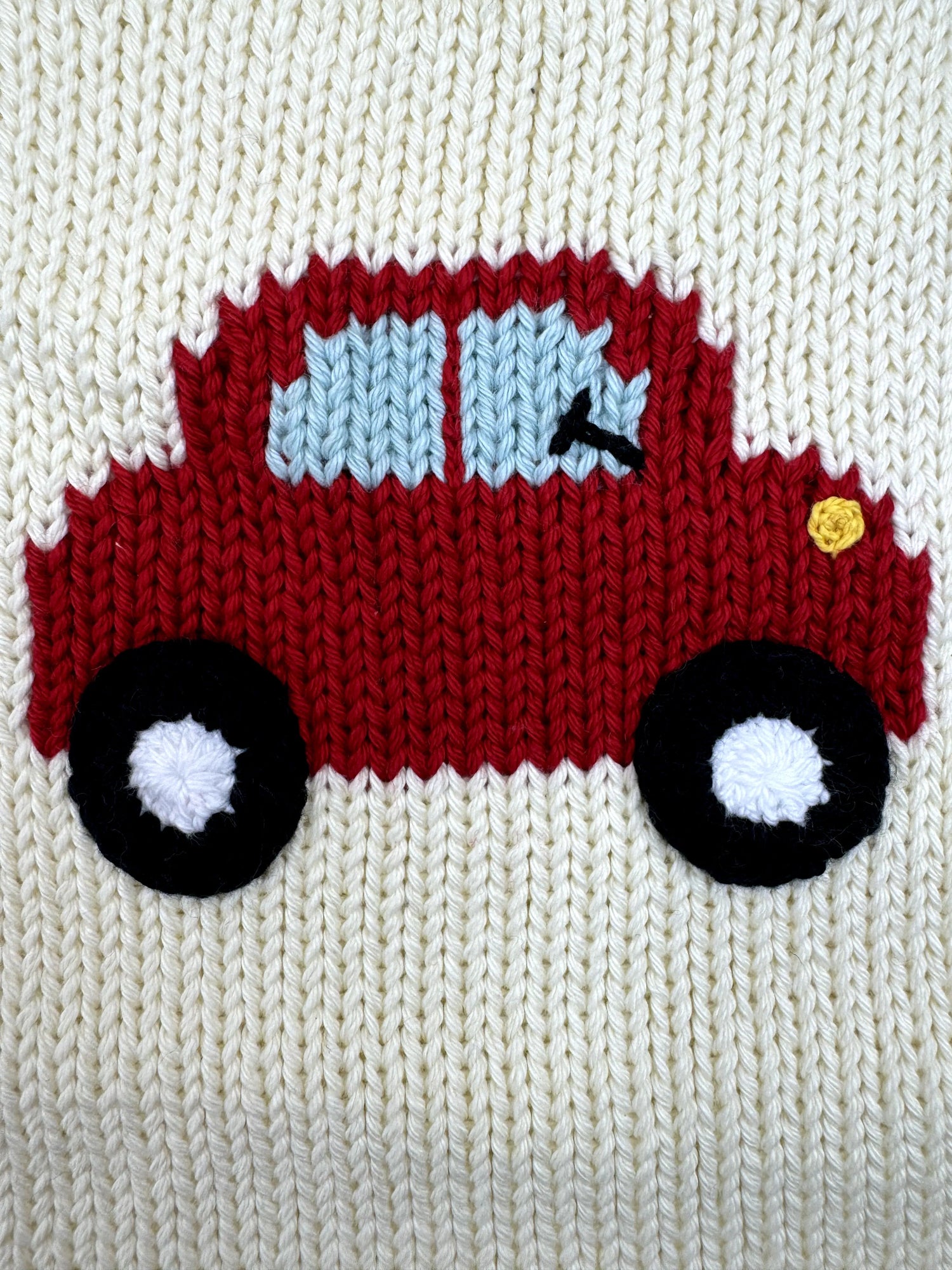 Knitted red truck with black wheels on a white background