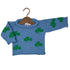 A blue knit baby sweater with green shamrock patterns, displayed on a wooden hanger against a white background.