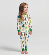 Child wearing a Christmas tree patterned onesie on a plain background