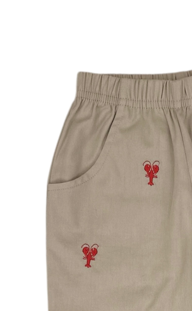 Beige pants with red lobster embroidery on a white background