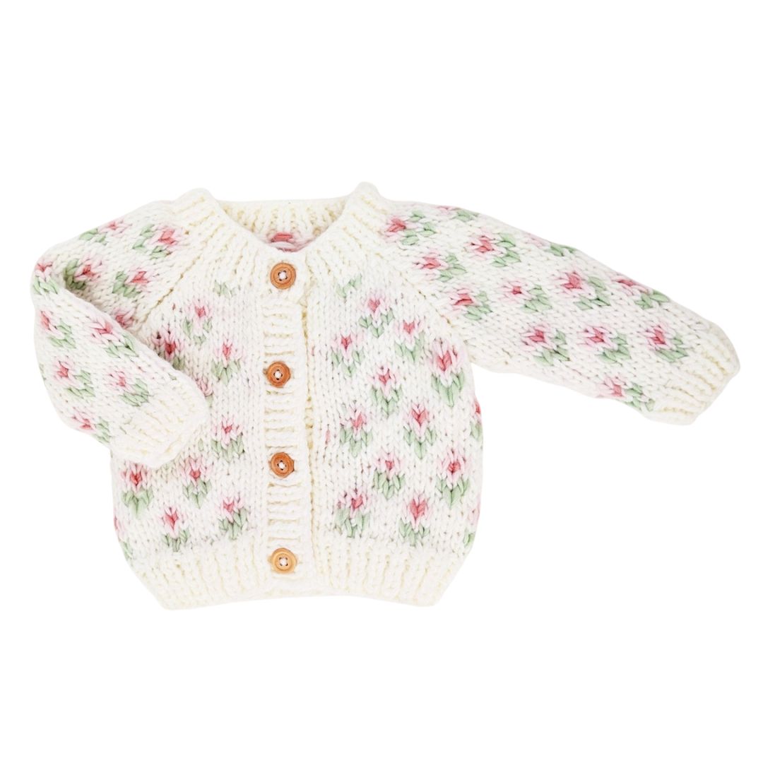 Knitted baby cardigan with floral pattern on a white background