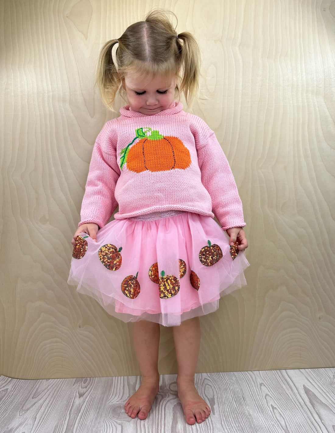 girl wearing pumpkin sweater and tutu