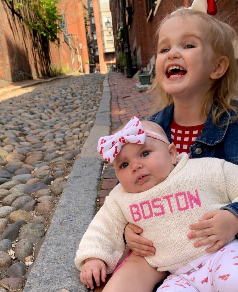 girl holding the baby wearing boston sweater