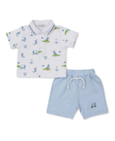 top is a white polo shirt and green and blue golf emblems all over and light blue shorts