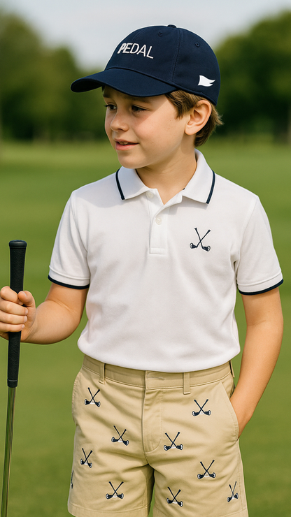 Young boy in golf attire on a golf course