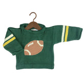 A green knit baby sweater with a brown football design on the chest and yellow and white stripes on the sleeves, hanging on a wooden hanger against a white background.