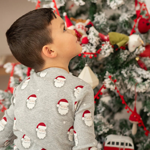 long sleeve grey pajamas with Santa Claus faces all over boy wearing