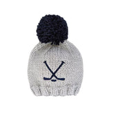 Knitted beanie with navy pom-pom and crossbones on a white background