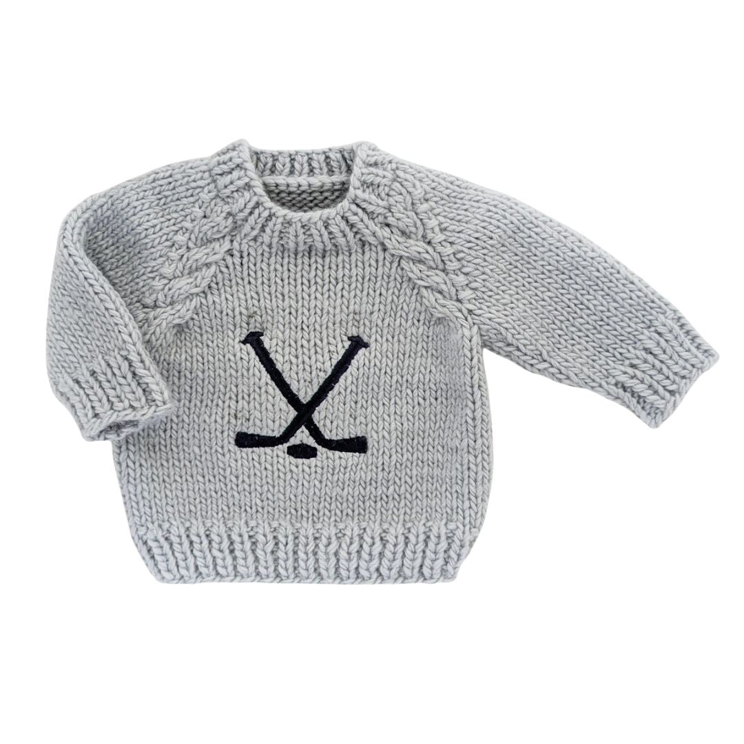 Gray knitted sweater with black hockey design on a white background