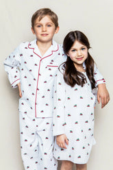 white pajamas with red trim and designs of red cars with trees on top