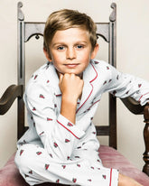 white pajamas with red trim and designs of red cars with trees on top