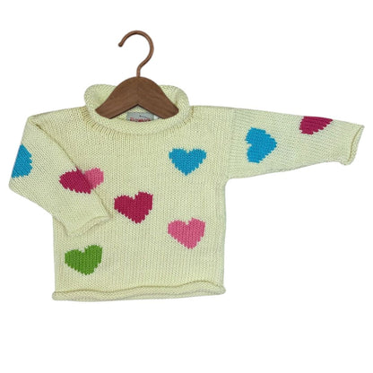 A cream-colored knit baby sweater with colorful knitted hearts in blue, pink, and green, displayed on a wooden hanger against a white background.
