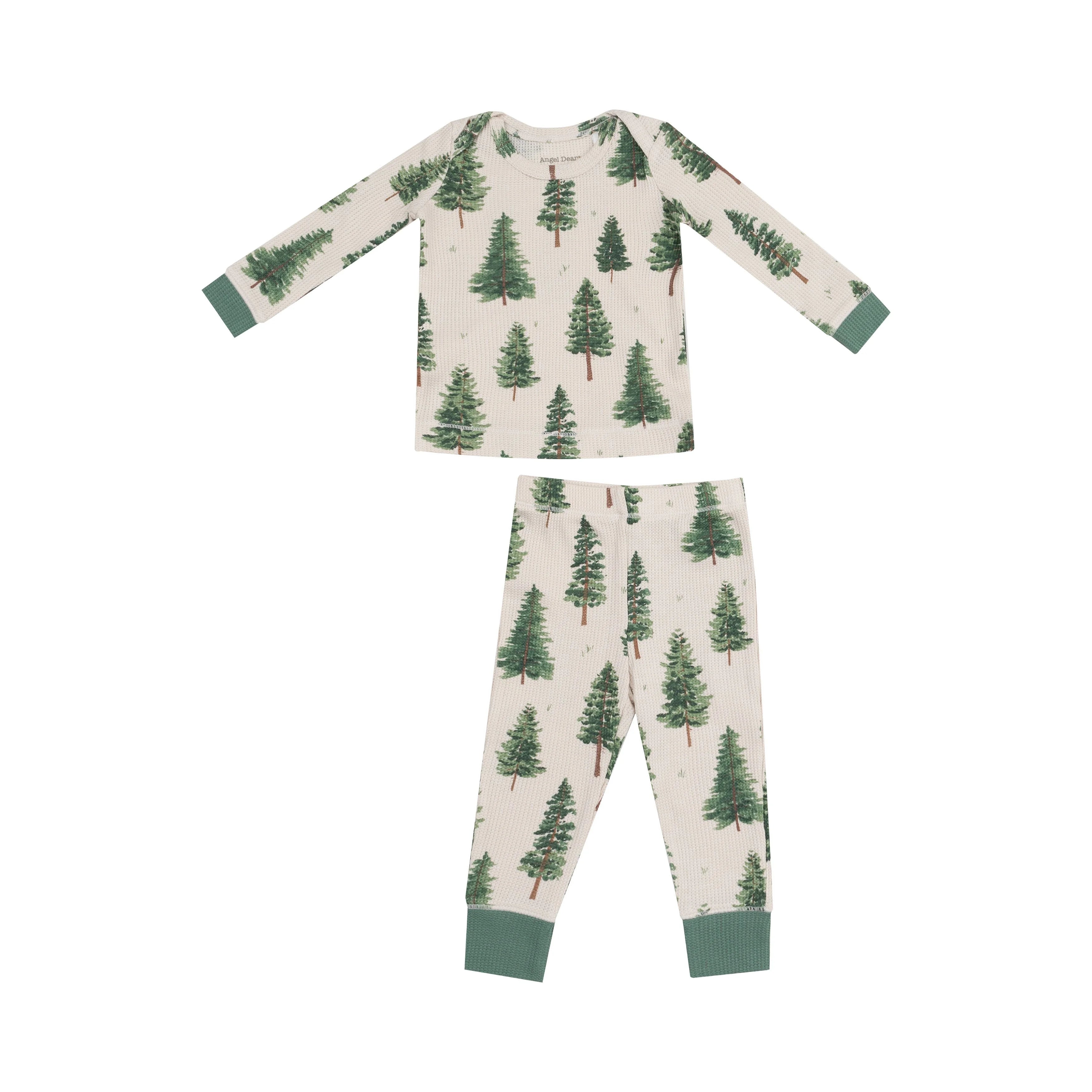 tan pajama set with green forest trees all over and green cuffs on wrists and ankles