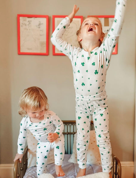 girls jumping with the shamrock pajamas on