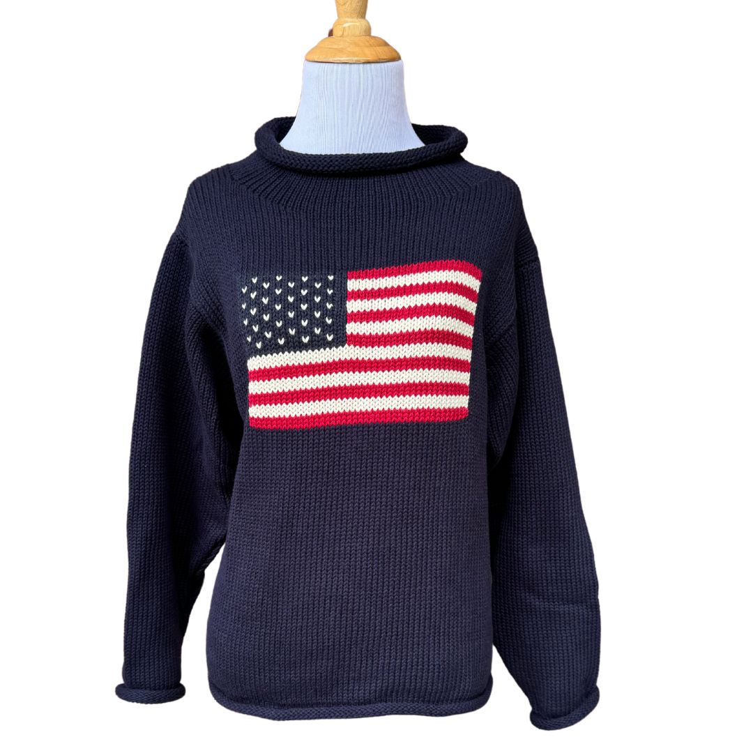 A navy blue chunky knit cotton sweater with a red and white striped roll neck featuring a knitted American flag design.