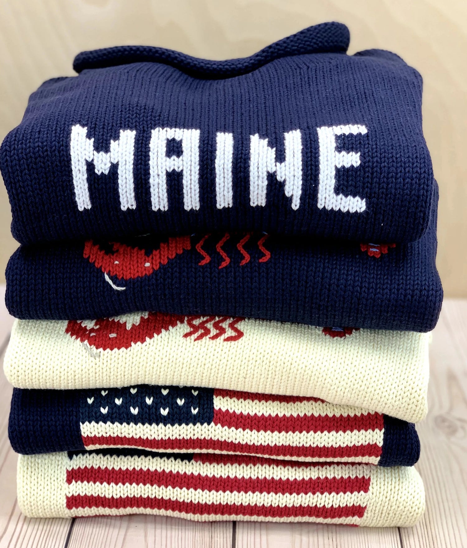 stack of ladies sweaters with Maine on top