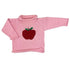 A pink ribbed knit roll neck sweater with a red apple and green leaf motif on the chest, displayed against a plain white background.