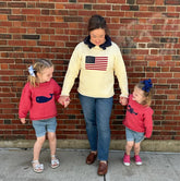 mom and daughters wearing red wagon sweaters