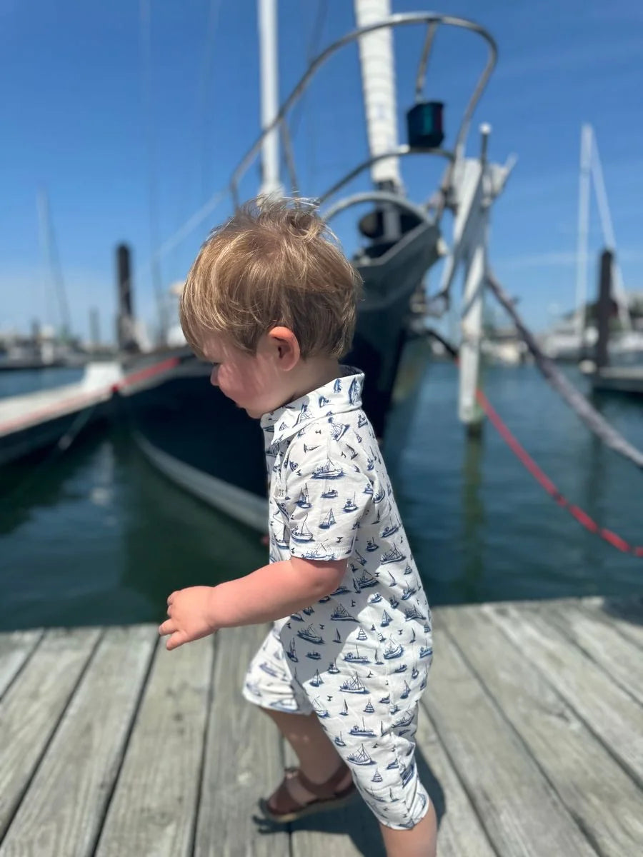 little boy wearing the romper on a dock