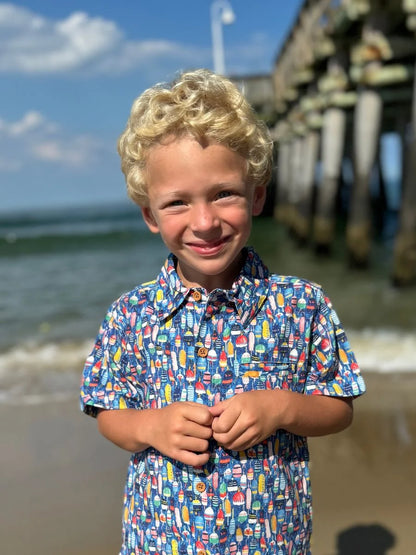 boy wearing buoy shirt on beach