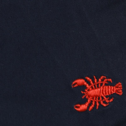 Red embroidered lobster on a navy blue fabric background