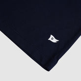 Navy blue fabric with a white logo on a light gray background