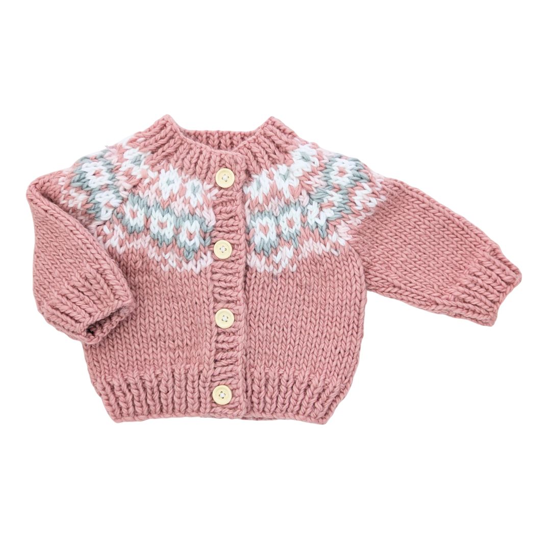 Pink knitted cardigan with fairisle patterns on a white background
